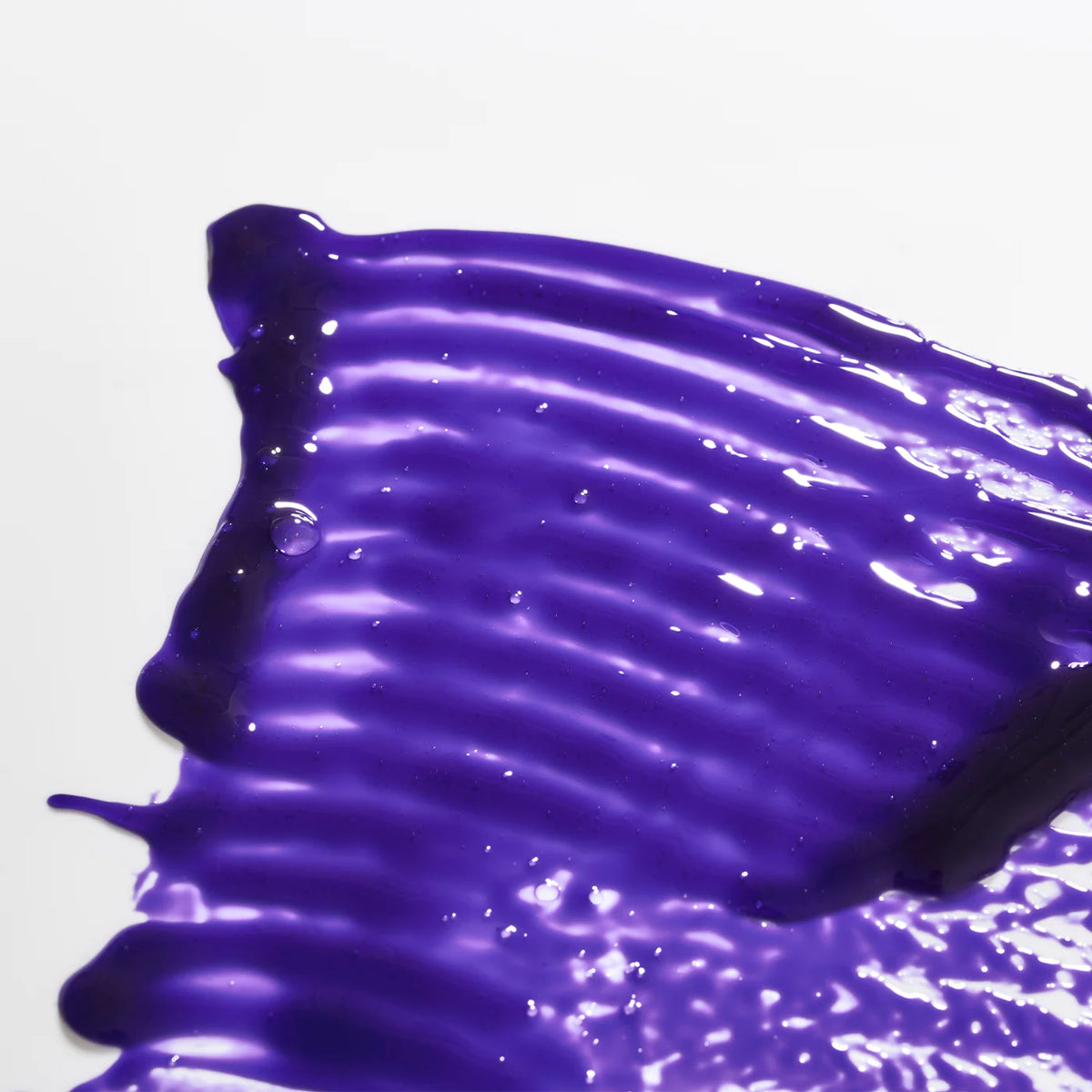 Close-up of the rich purple texture of ROYAL Platinum Shampoo spread across a clean white surface.