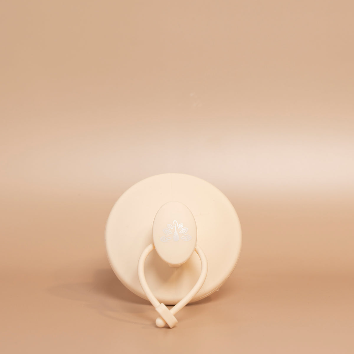 Beige ROYAL scalp scrubber displayed with its silicone bristles facing upward, highlighting its ergonomic design.