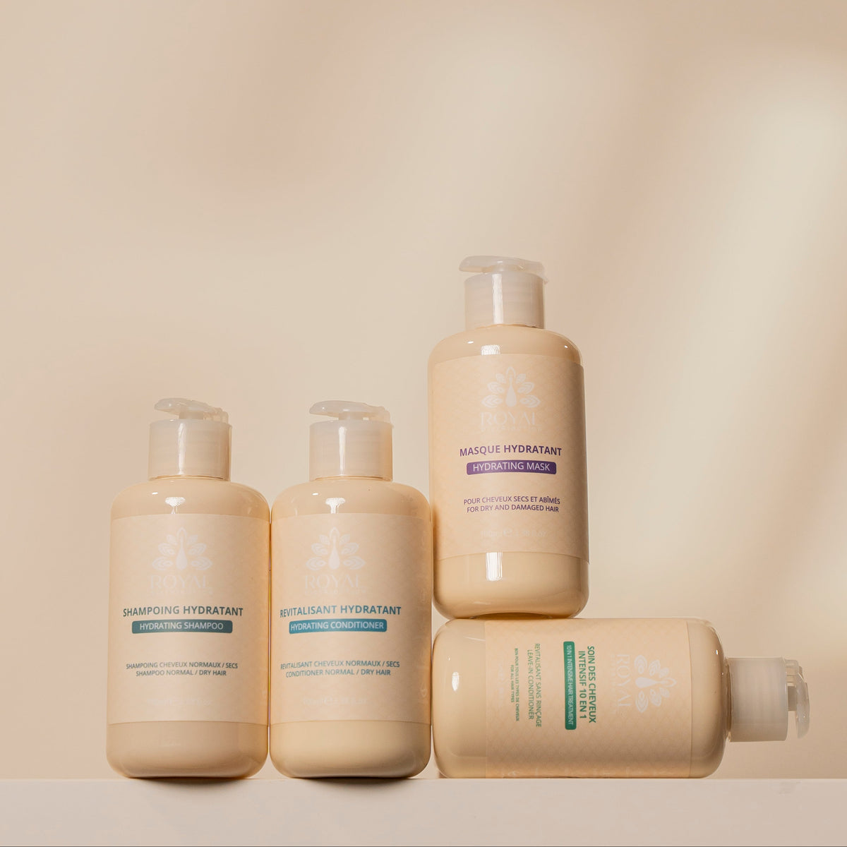 ROYAL Hydrating Shampoo, Hydrating Conditioner, Hydrating Mask and 10 in 1 Leave-In Conditioner arranged together against a minimalist beige background.