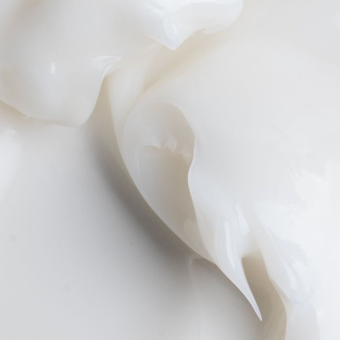 Close-up of the smooth white creamy texture of ROYAL Leave-In 10-in-1, highlighting its rich and silky consistency.