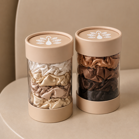 ROYAL satin hair scrunchie collections featuring elegant light neutrals and rich brown tones, presented in two clear cylindrical containers with nude beige lids and signature ROYAL logos.