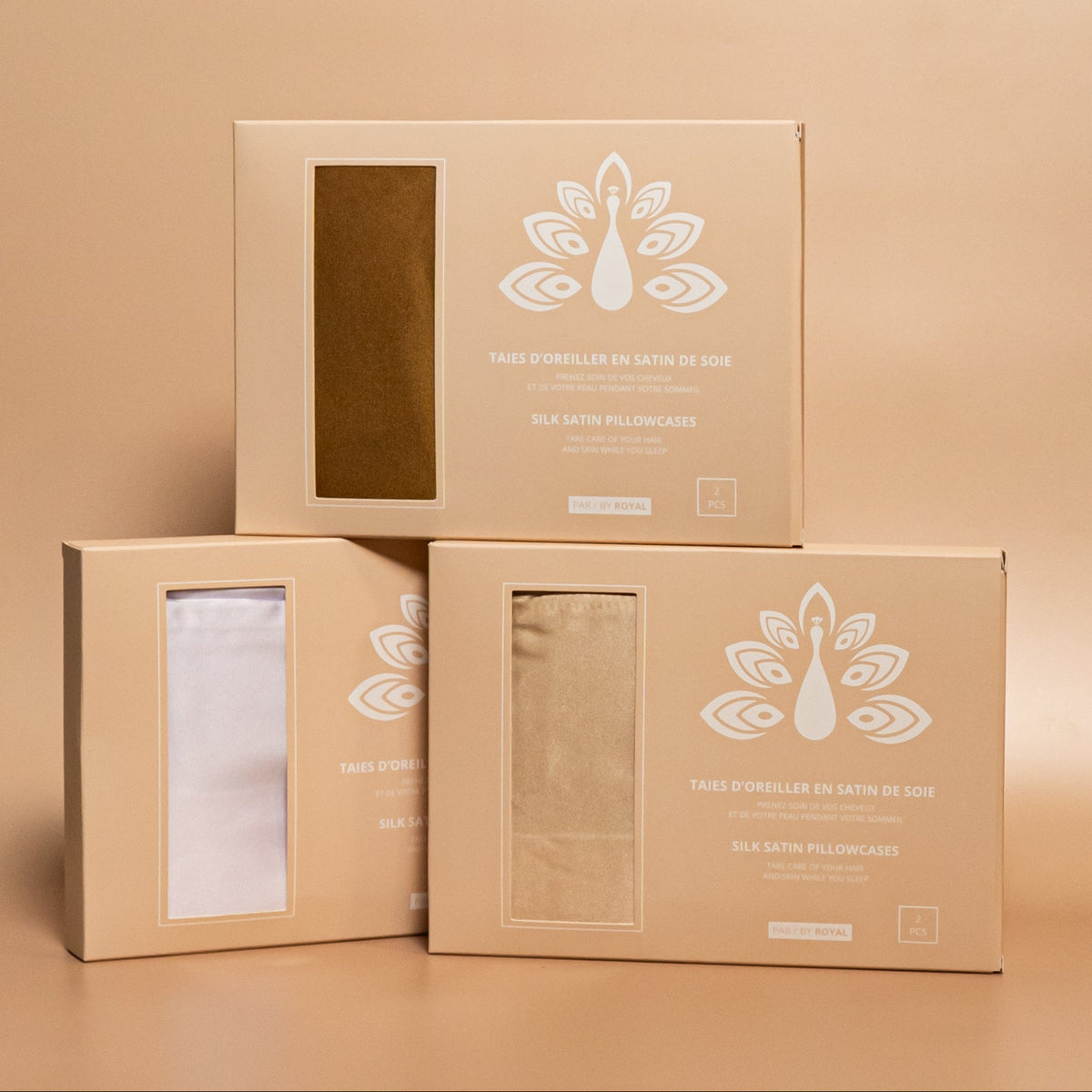 Three ROYAL silk satin pillowcase boxes displayed together against a beige background, with the pillowcases inside.