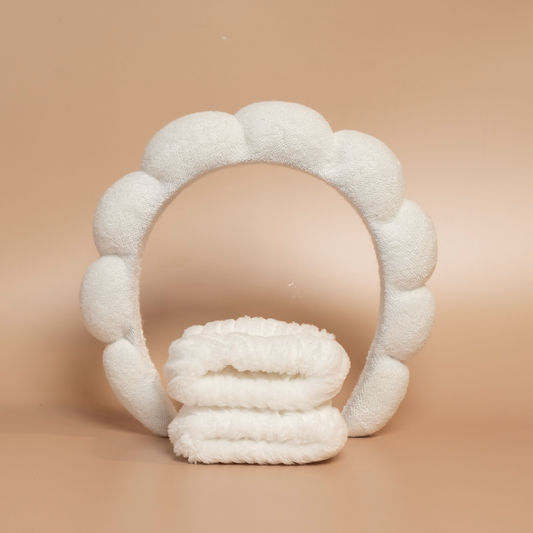 White ROYAL hair care headband and matching fabric wristbands displayed together against a beige background.
